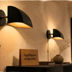 Appliques murales originales en métal noir mat, halo lumineux sur mur clair